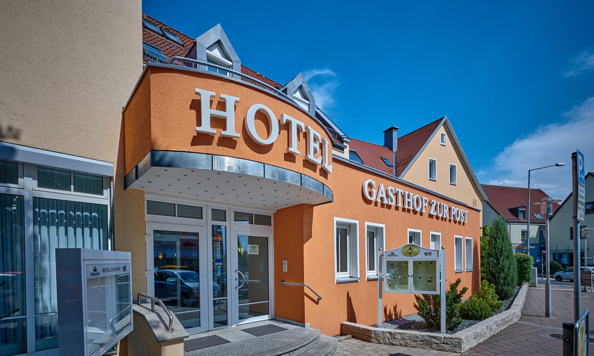 Das orange Gebäude des Hotels im Nürnberger Land an einem sonnigen Tag